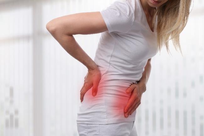 אישה סובלת מכאבים בבטן התחתונה שיכולים להעיד על אבנים בדרכי השתן 